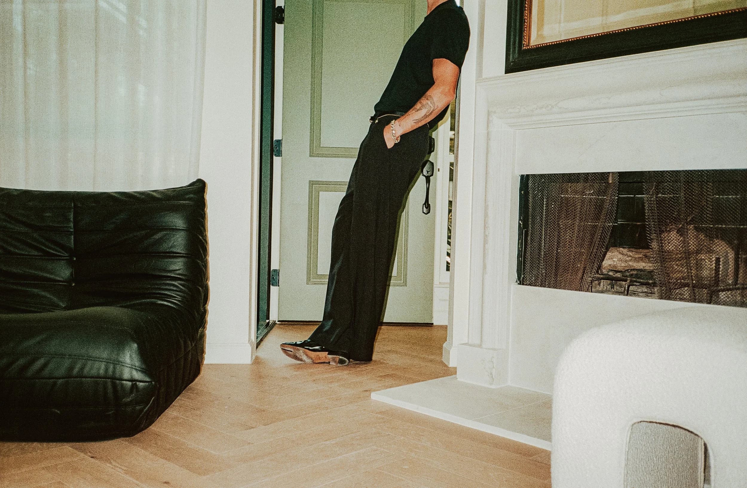 Interior at The Clarksville with a marble fireplace, herringbone wood floors, and a black leather sofa