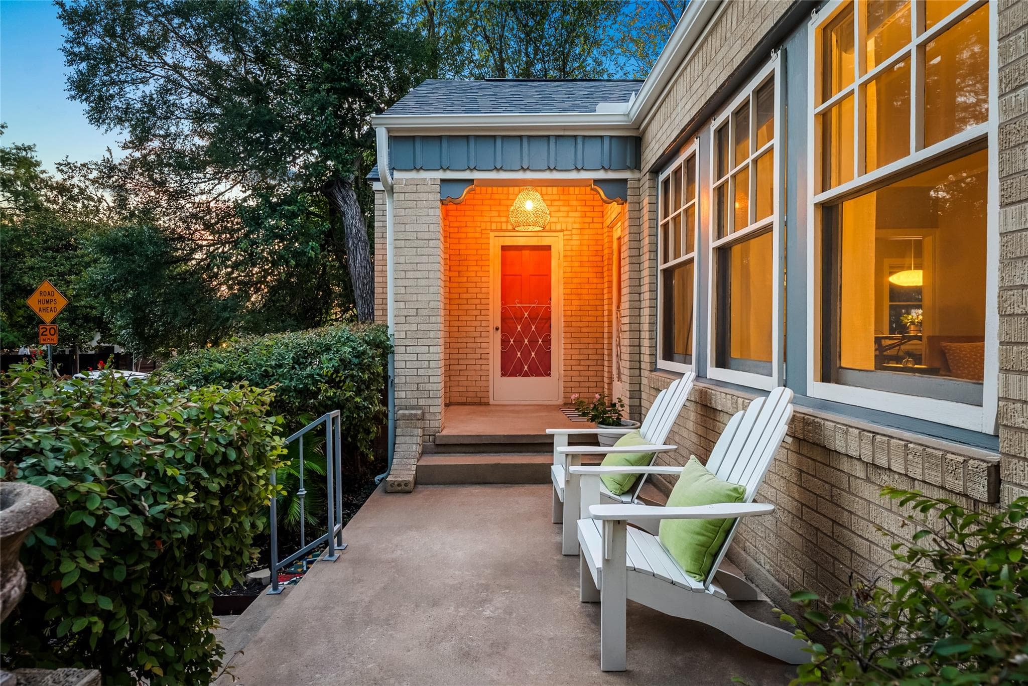 A welcoming front porch features a bold red door