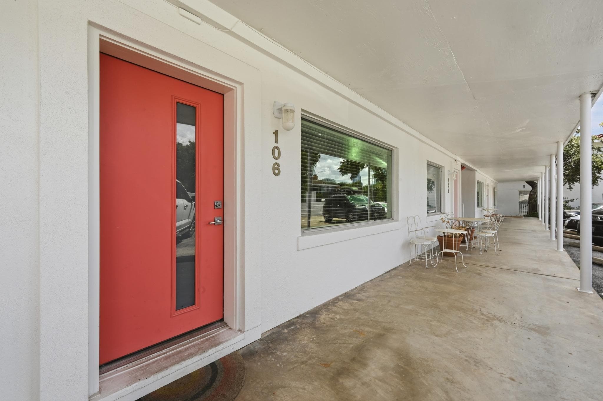A vibrant coral entry door welcomes guests to thi