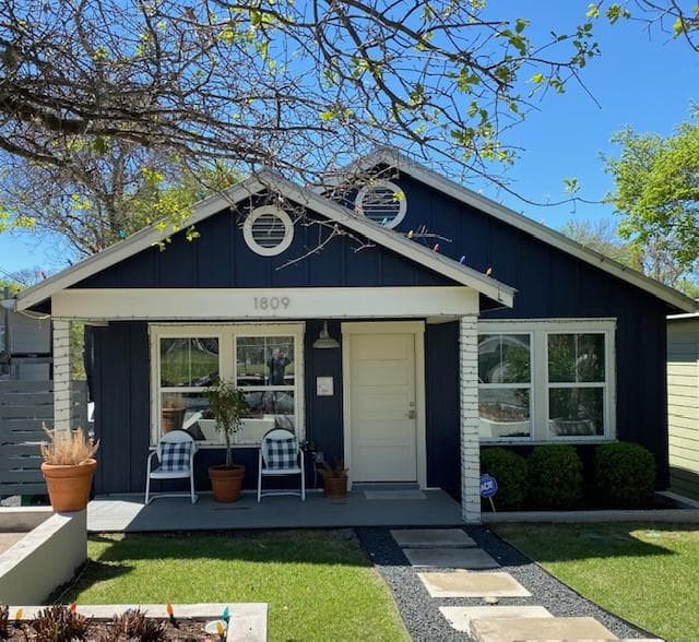 Bungalow-style home with a front lawn and board a