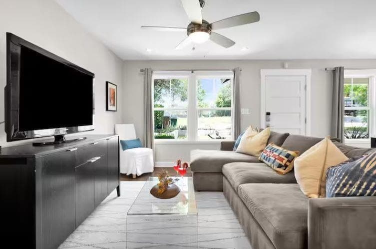 Living room with a ceiling fan and plenty of natu