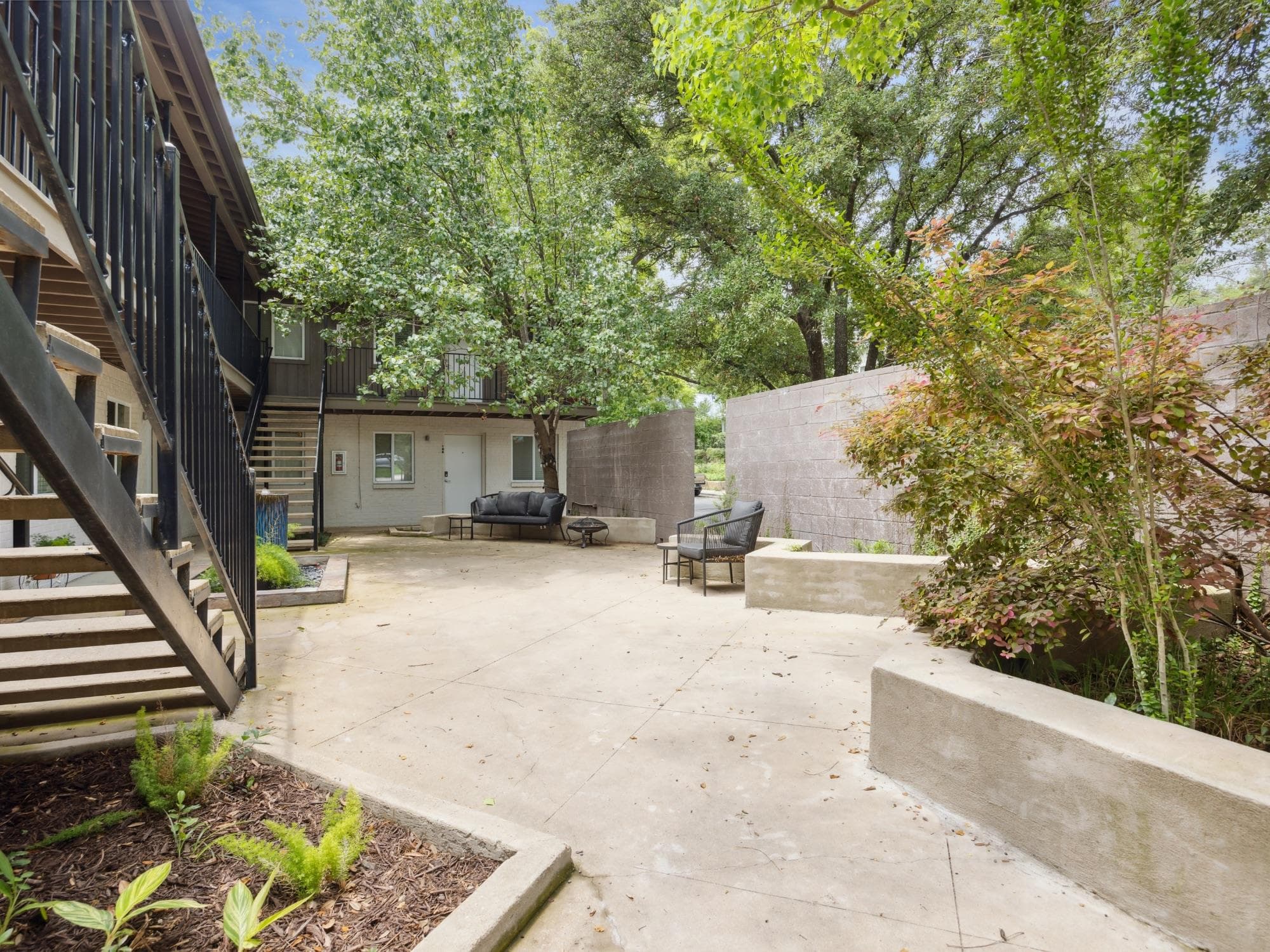 Concrete courtyard featuring built-in planters an