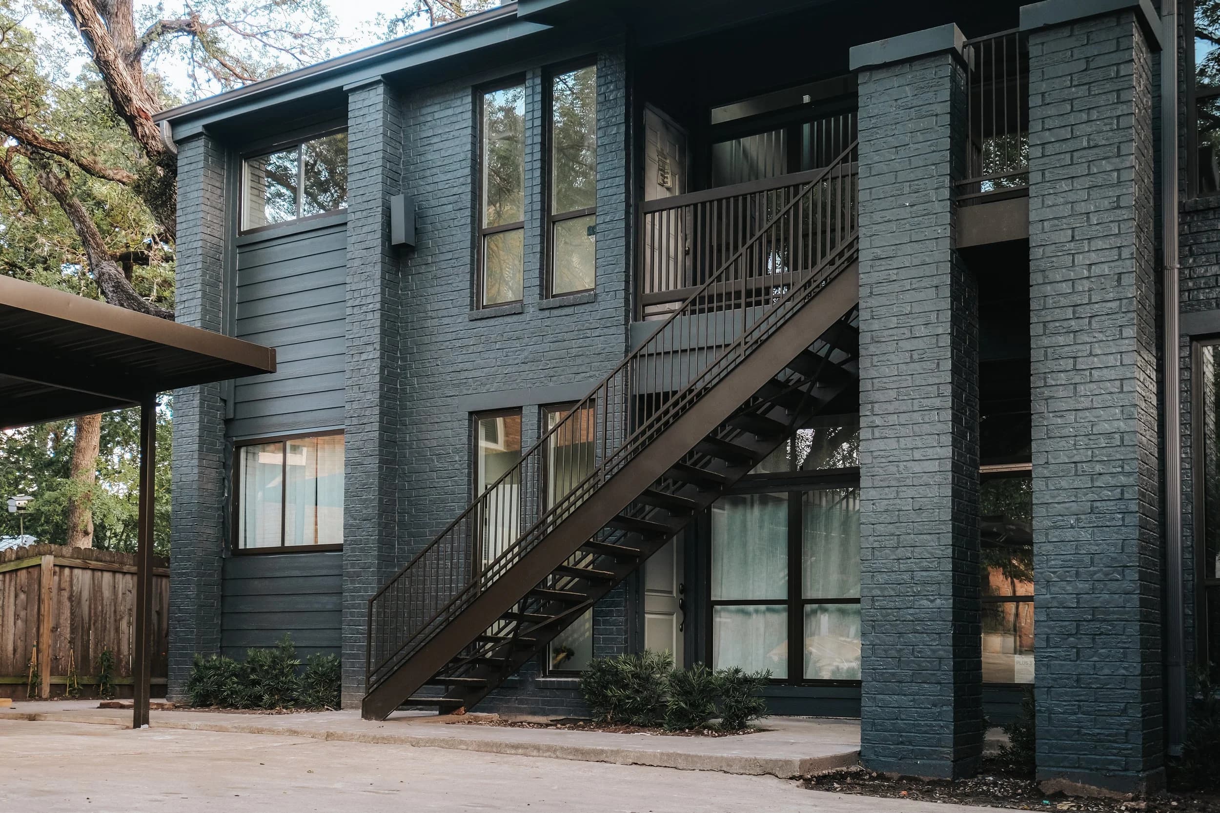 Exterior of The Clarksville Condominiums, a reimagined dark-brick mid-century building at 1711 Enfield Road, Austin